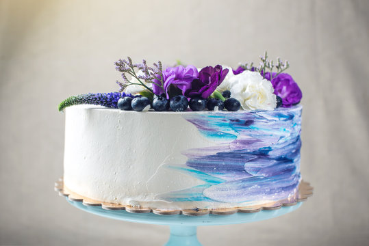 Colorful wedding cake with lovely purple flowers and blueberries