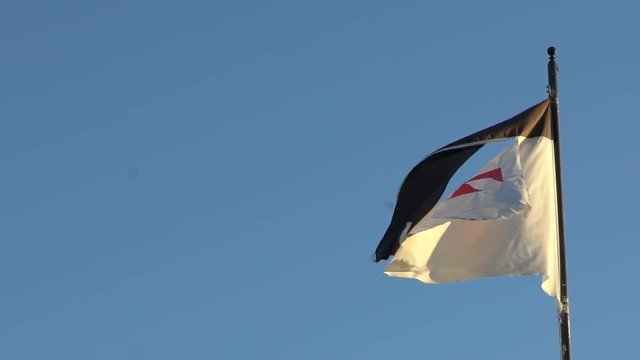 Slow motion Templar banner wind and blue sky in Castle Medieval Of The Knights Of Templars at Jerez de los Caballeros, Spain.-Dan