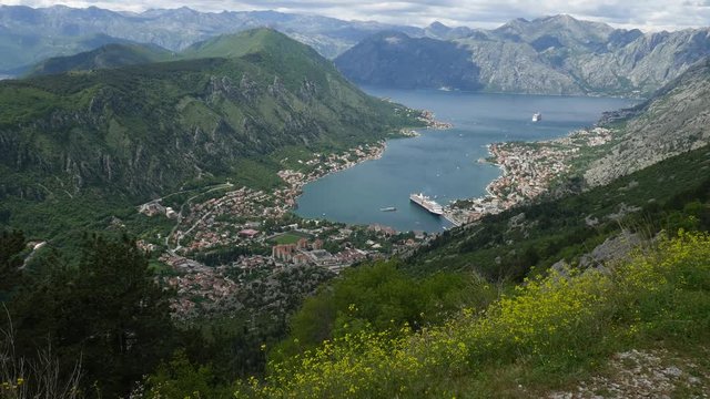 Bay of Kotor from the heights. View from Mount Lovcen to the bay. View down from the observation platform on the mountain Lovcen. Mountains and bay in Montenegro. The liner near the old town of Kotor.