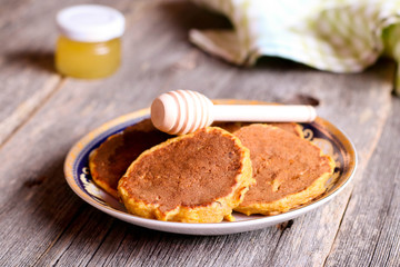 pumpkin pancakes on a plate for breakfast with honey, horizontal
