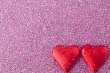 Two red hearts on pink background texture