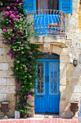 The door and balcony entwined with bougainvillea on Birgu. Malta