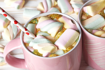 Two pink cup with cocoa and marshmallows
