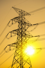 Electricity pylons and lines at sunset