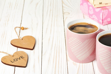 Two coffee cup, wooden hearts and gift boxes