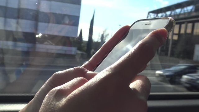 4K Young Asian Woman Used Touchscreen Smartphone Device, Surfing the internet and checks social network, Checks her phone during sun day ride in the bus at Spain-Dan