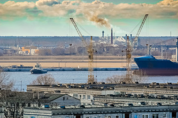 Fototapeta na wymiar Blue cargo container ship moving past the Riga city