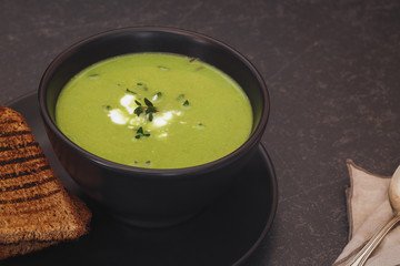 Healthy homemade green soup with herbs. Macro, selective focus, copy space