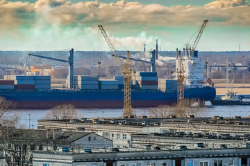 Fototapeta na wymiar Blue cargo container ship moving past the Riga city