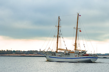 Fototapeta na wymiar White sailing ship coming from Baltic sea and entering Riga
