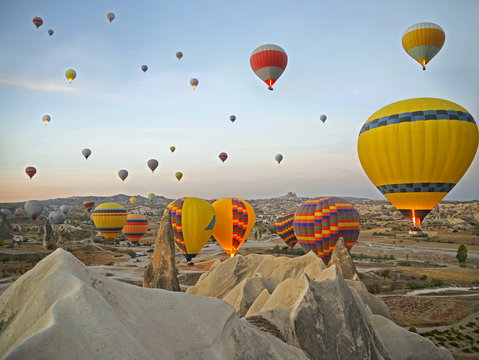 Colorful hot air balloons flying over the valley at Cappadocia, Turkey. Volcanic mountains in Goreme national park
