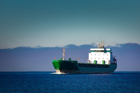 Green Cargo Ship Moving In Still Water Of Baltic Sea