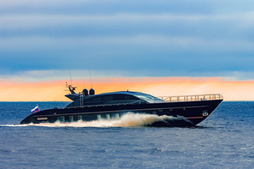 Black elite speed motor boat moving fast from Baltic sea
