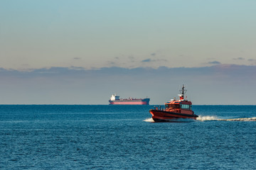 Orange pilot ship moving fast from Baltic sea