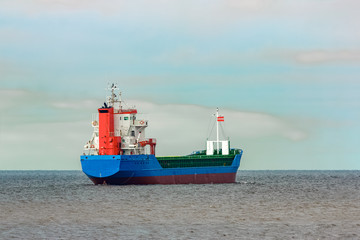 Blue cargo ship entering the Baltic sea. Riga, Europe