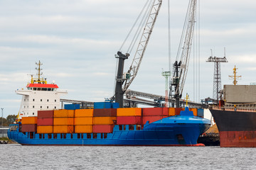 Fototapeta premium Blue container ship loading in cargo port of Europe