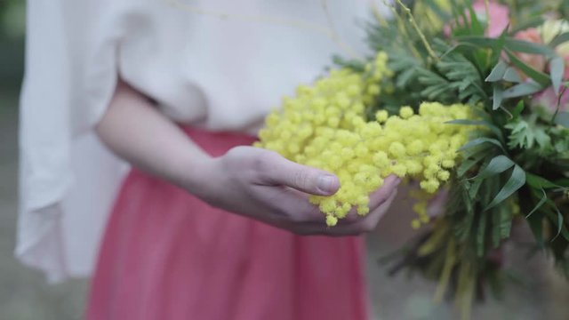Frauenhand streichelt gelben Blumenstrau&szlig;