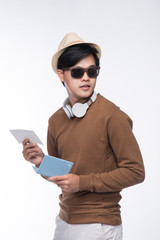 Happy young tourist asian man holding passport over grey background