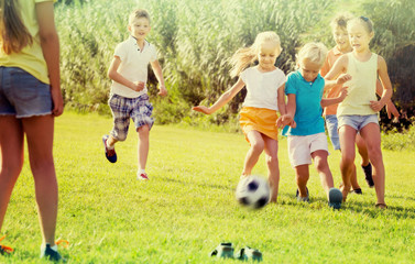 Obraz na płótnie Canvas kids kicking football in park