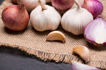 Garlic and onion on the black stone table