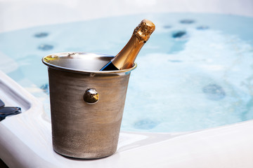 bottle of champagne cooling by hot tub - romantic relaxing holiday concept