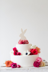Osterhase auf Kuchen mit frischen Blumen im Frühling