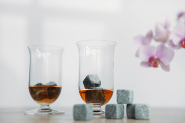 Stones for cooling whiskey and glases tulup on light wooden background