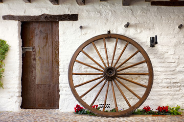 Obraz premium wooden cartwheel and door in andalusian patio
