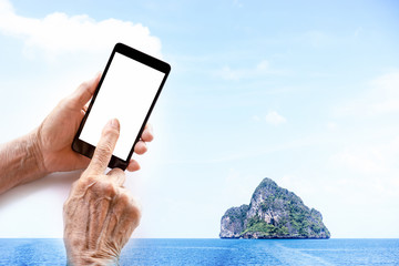 Always Connected, older person, hand holding and touch smart phone with blank white screen isolated, island seascape background, double exposure