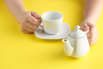 teapot pouring tea isolated on yellow background