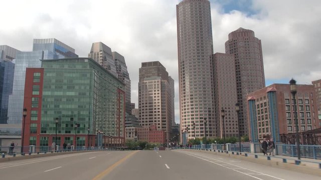 FPV, CLOSE UP: Traveling towards high glassy window pattern skyscrapers in Downtown Boston financial district skyline, USA. Driving on busy highway in metropolitan city overlooking office buildings