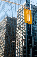 Spiegelnde Glasfassade mit oranger Ampel