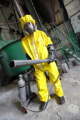 professional in protective uniform, mask, gloves with fire extinguisher in industrial building