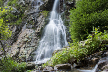 Fototapeta premium Waterfall on mountain river in Carpathian Mountains , Romania