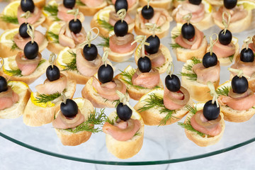 Catering of canape with olives, lemon and salmon