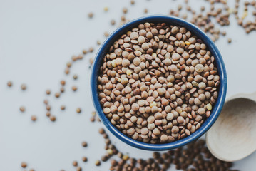 Lentils vegetarian food in ceramic bowl on a white table.