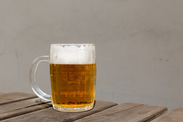 Golden unpasteurised fresh beer with foam in glass mug