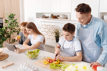 Little positive boy cooking with his father