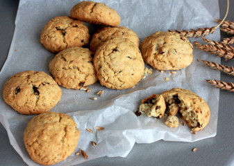 Oatmeal cookies on baking paper with ears of rye