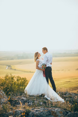 stylish gorgeous couple newlyweds standing on the rocks in the mountains