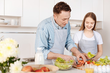 Joyful smiling father cooking with his daughter