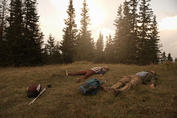 Tired hikers lying on grass after a trek