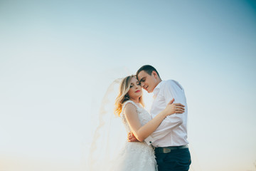 Fototapeta na wymiar wedding couple embracing under the blue sky