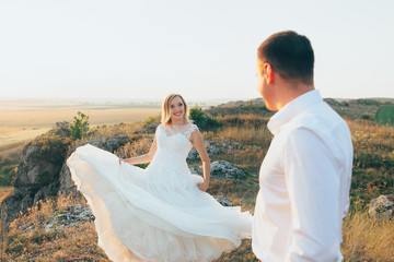 happy newly married couple posing in the mountains