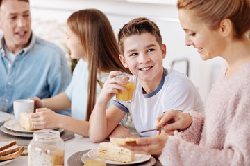 Obraz na płótnie Canvas Cheerful boy having breakfast with his family