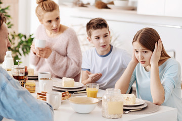 Obraz na płótnie Canvas Depressed girl having breakfast with her family