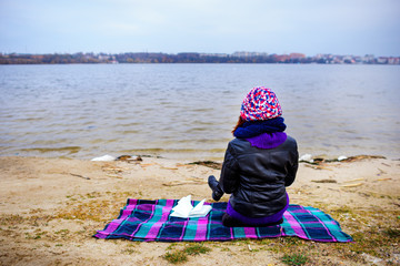 A woman on the beach starring at the restless Sea