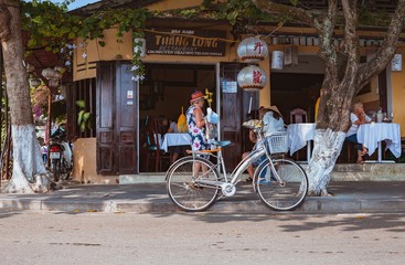 HOI AN, VIETNAM - MARCH 15, 2017: Group of people travel Hoian old town, ancient house, country heritage, city friendly with environment, walk, bicycle or pedicab on street, traveller visit at Vietnam