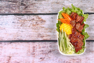 Mixed vegetable salad topped sliced grilled pork