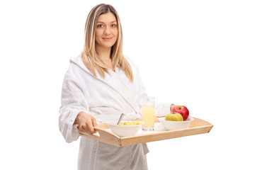 Obraz na płótnie Canvas Young woman in a bathrobe holding a breakfast tray